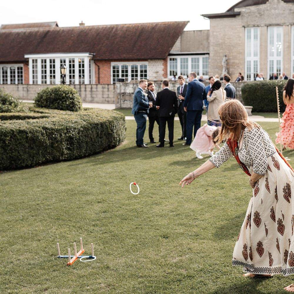 Lady playing a garden game on the lawn at Froyle Park, a wedding venue in Surrey