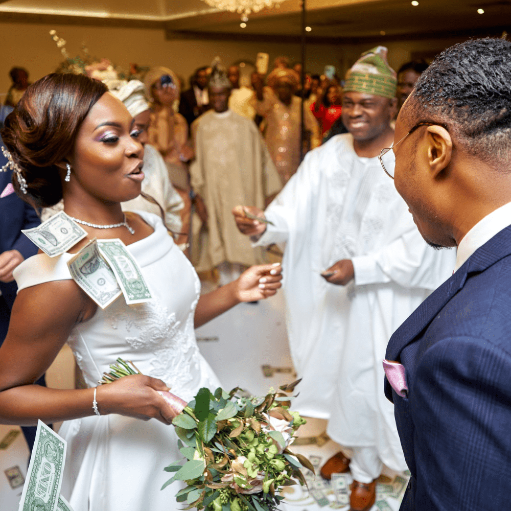 A stunning African-Caribbean bride enjoys a money dance at Froyle Park at her wedding reception in the Grand Ballroom