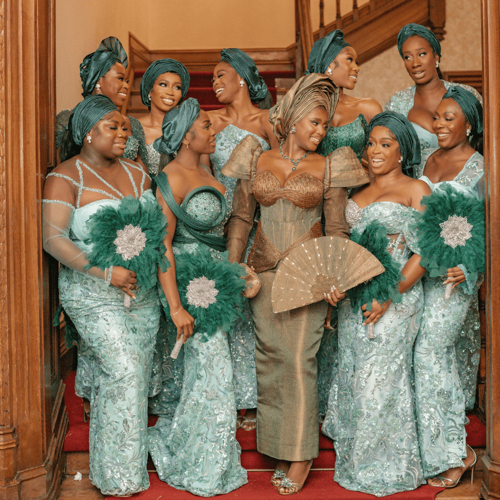 A Nigerian bridal party in Yoruba traditional outfits pose on the Great Hall Staircase at Froyle park