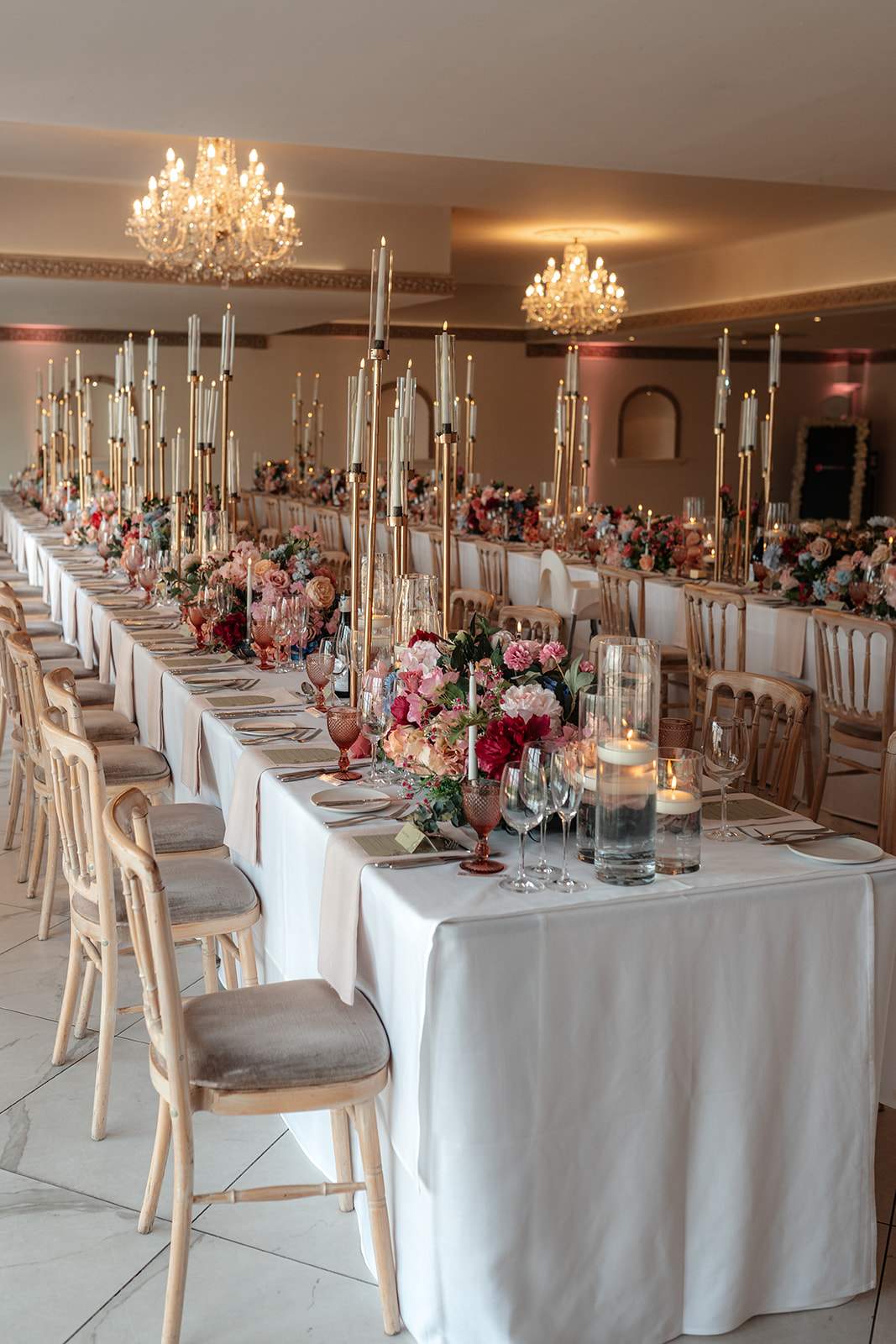The Grand Ballroom at Froyle Park, styled with long banquet tables, elegant tapered candles and pastel florals