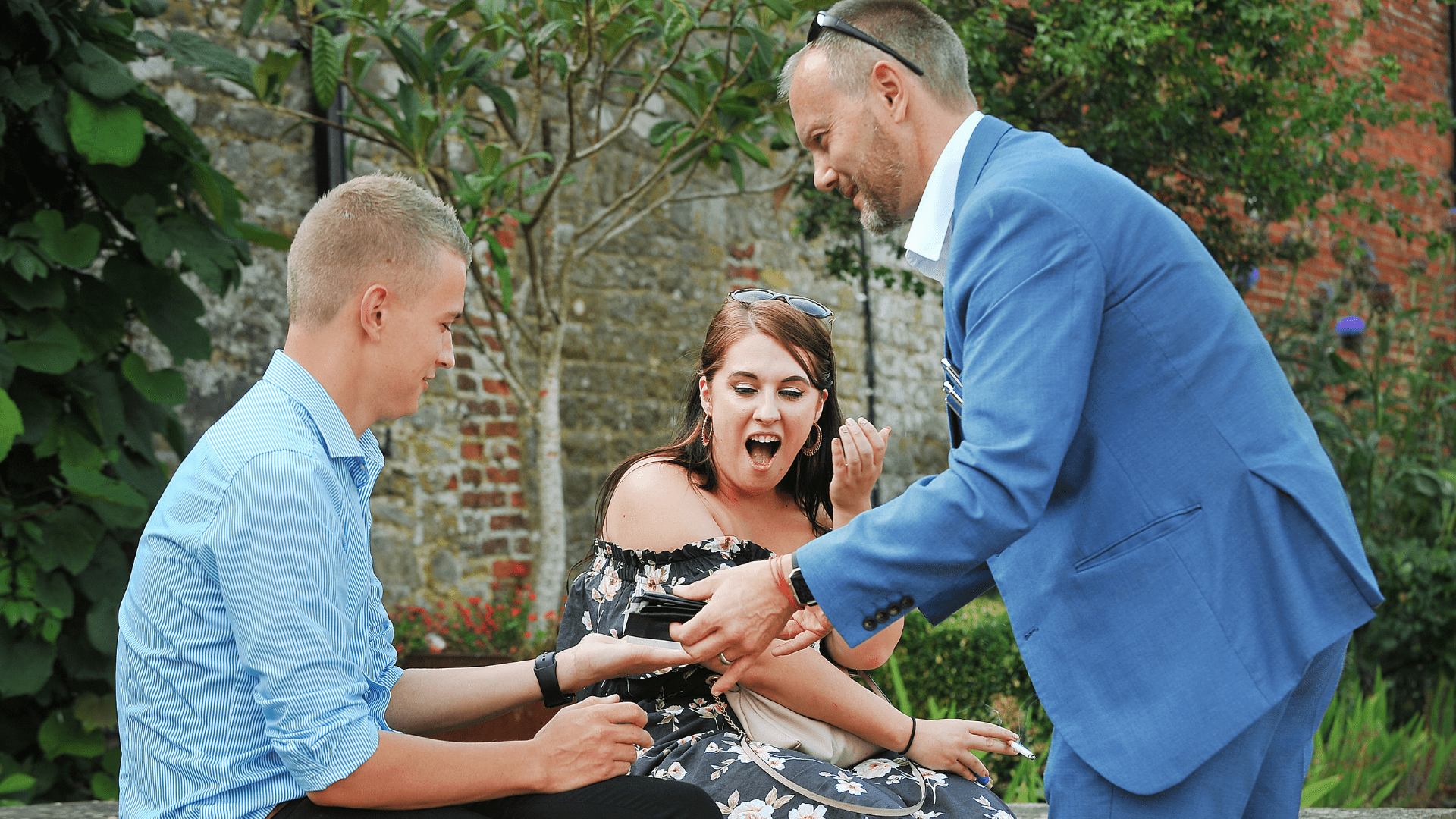 A couple are amazed by the close-up magic of Simon Alexander at a wedding