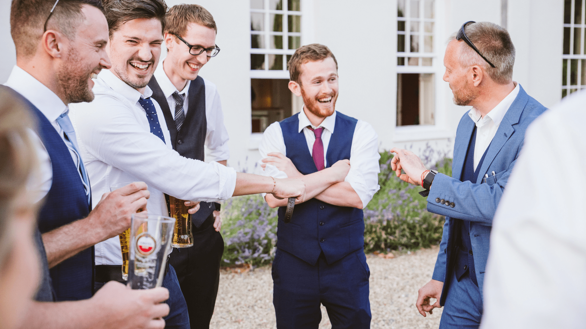 A group of ushers are wowed by the close-up magic of Simon Alexander at a wedding