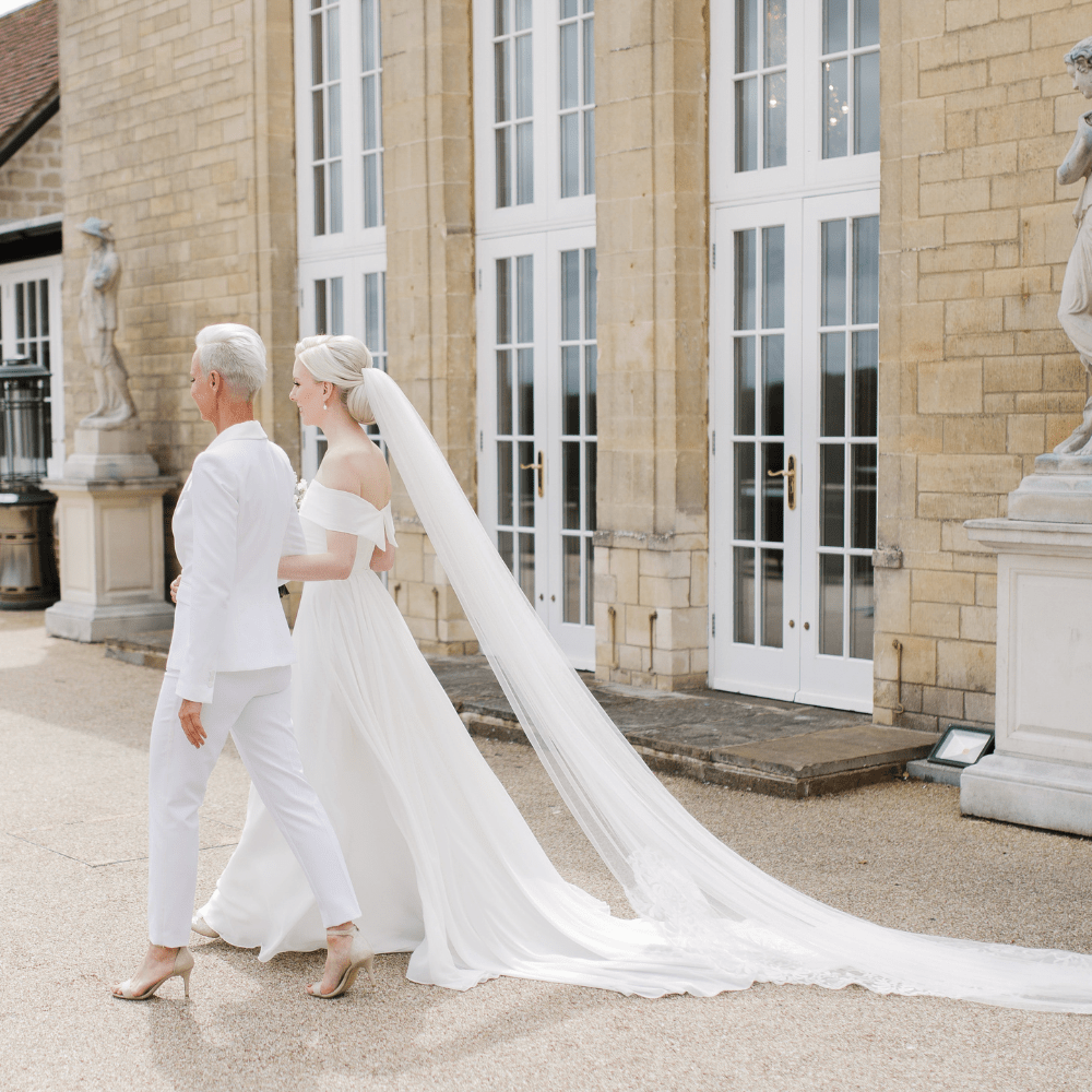 Two Brides stroll on the terrace at Froyle Park