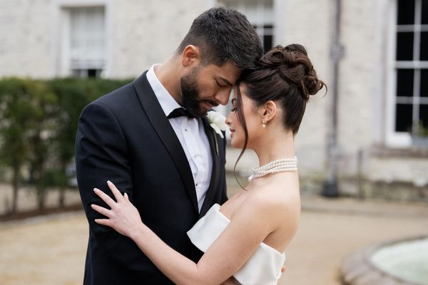 A bride and groom in front of the manor house at Froyle Park wedding venue in Hampshire