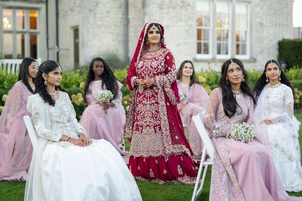 An Asian bride with her bridesmaid on the lawns at Froyle Park