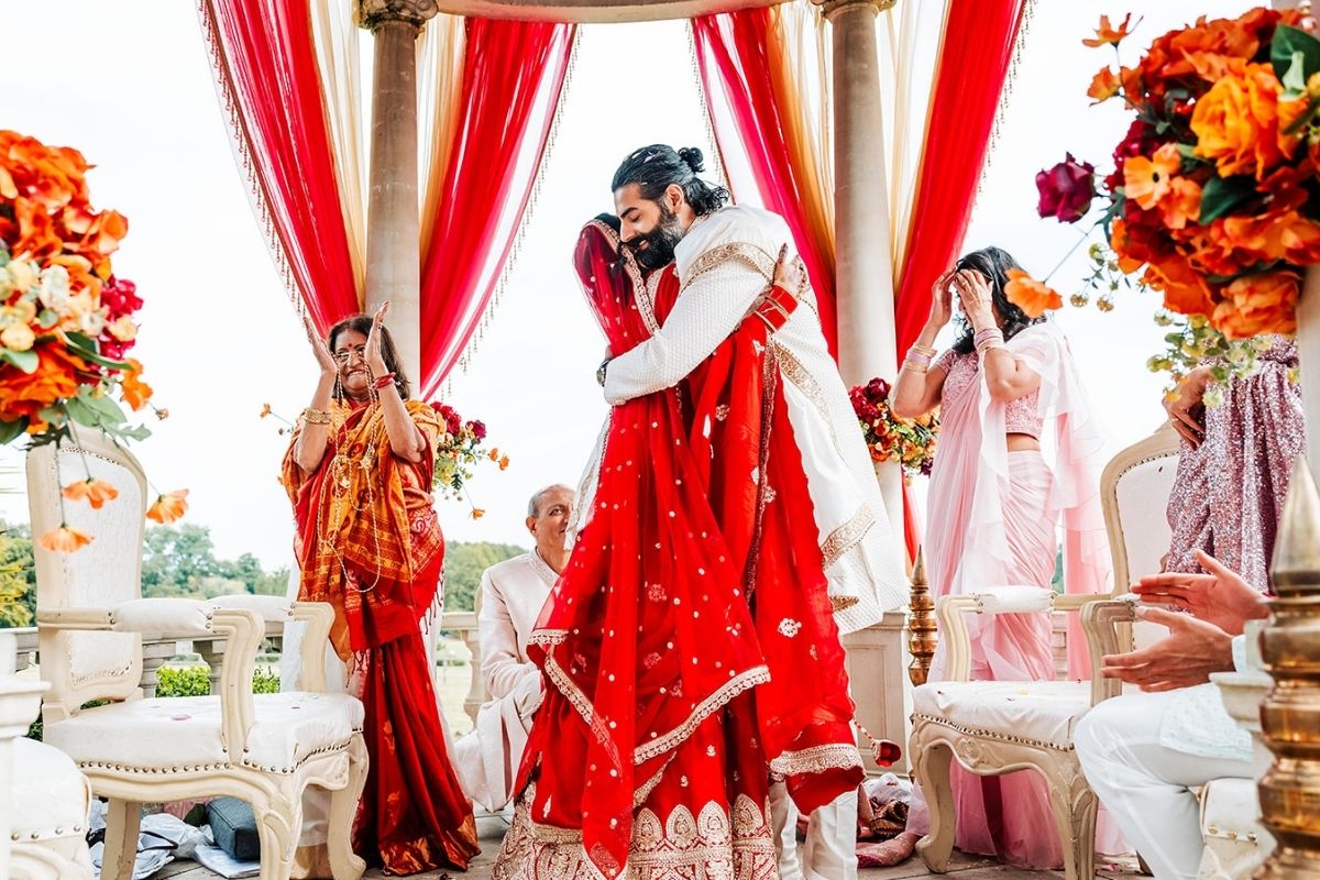 A Hindu Bride & Groom embrace after during their religious ceremony at Froyle Park's outdoor wedding dome