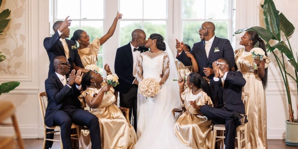 A bride and groom with their wedding party in The Drawing Room at Froyle Park